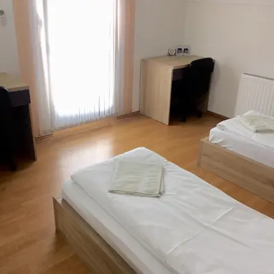 a room with two beds and a desk in it at City Bridge Guest House in Bihać