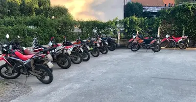 a row of motorcycles parked in a parking lot at City Bridge Guest House in Bihać