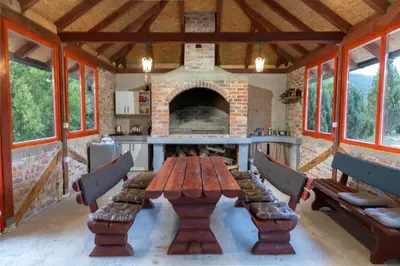 a wooden table in a room with a fireplace at Nessy Bihać in Bijelo Brdo