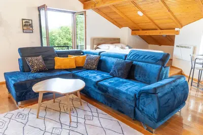a blue couch in a living room with a table at Nessy Bihać in Bijelo Brdo