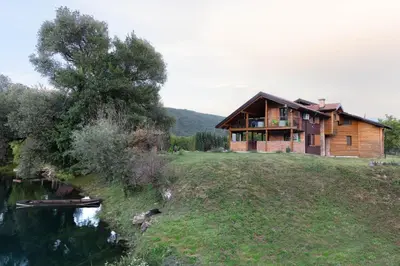 a wooden house on a hill next to a river at Nessy Bihać in Bijelo Brdo