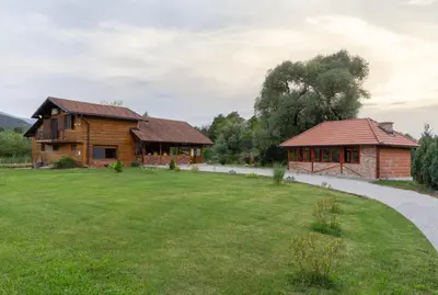 a house and a building with a grass yard at Nessy Bihać in Bijelo Brdo