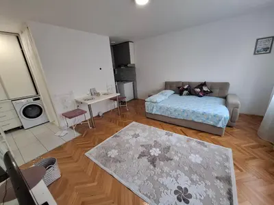 a living room with a bed and a table at Apartman TEA in Ivišovo Greblje