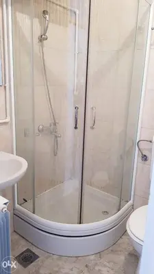 a shower with a glass door in a bathroom at Apartman TEA in Ivišovo Greblje