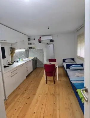 a room with a kitchen and a table and a dining room at Le Solei Apartment in Visoko