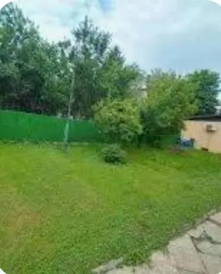 a yard with green grass and trees and a house at Le Solei Apartment in Visoko