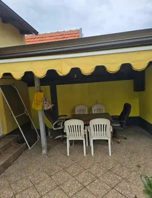 a patio with a table and chairs in a building at Le Solei Apartment in Visoko