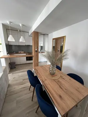 a dining room with a wooden table and blue chairs at Villa Laura in Gornji Vakuf
