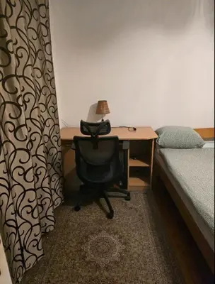 a bedroom with a desk and a chair next to a bed at Pyramid Apartment in Visoko