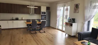 a kitchen and living room with a table and chairs at Villa Zeleno Brdo in Visoko