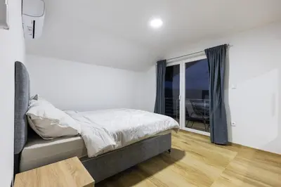 a white bedroom with a bed and a window at Villa Zeleno Brdo in Visoko