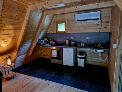 a kitchen in a log cabin with a sink at Fikro's Resort in Kulen Vakuf