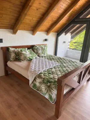a bed in a room with a large window at Vikendica Radoš