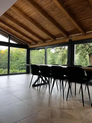 a table and chairs in a room with windows at Vikendica Radoš
