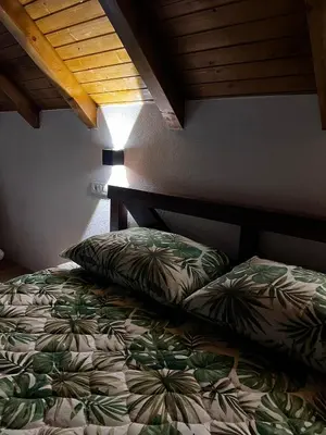 a bedroom with a bed with pillows on it at Vikendica Radoš