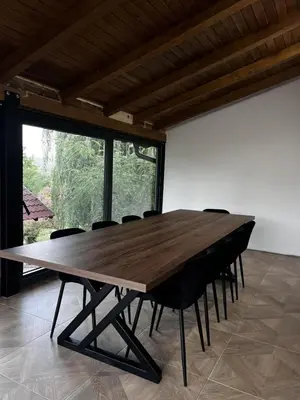 a large wooden table in a room with chairs at Vikendica Radoš
