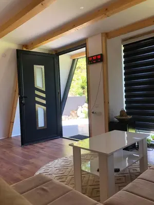 a living room with a glass table and a door at Vikednica ZEA