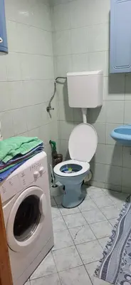 a bathroom with a toilet and a washing machine at Apartman Kovacevic Prnjavor Republika Srpska in Prnjavor