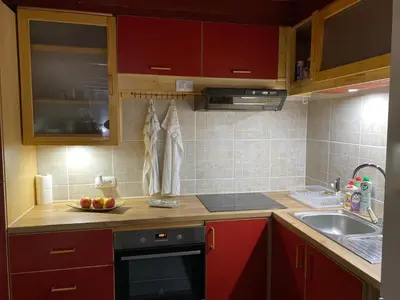 a kitchen with red cabinets and a sink at Country House Bijela Voda in Bihać