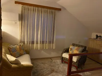 a living room with two chairs and a window at Country House Bijela Voda in Bihać