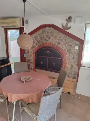 a dining room with a table and a fireplace at Country House Bijela Voda in Bihać