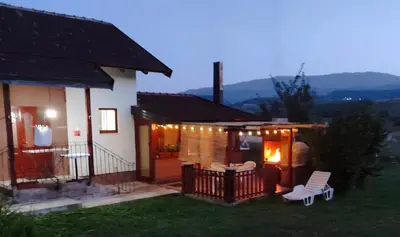 a house with a porch with chairs and lights at Country House Bijela Voda in Bihać
