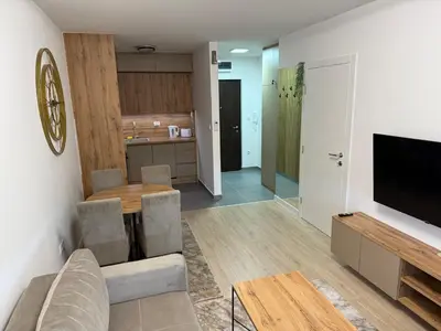 a living room with a couch and a table and a television at Apartman Premium in Doboj