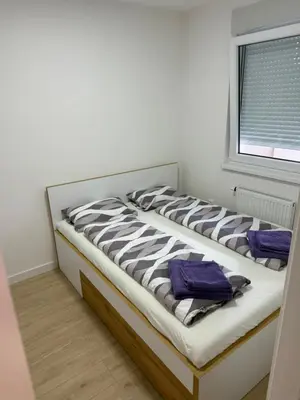 a large bed in a room with a window at Apartman Premium in Doboj