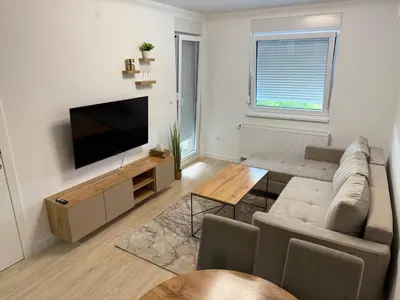 a living room with a couch and a flat screen tv at Apartman Premium in Doboj