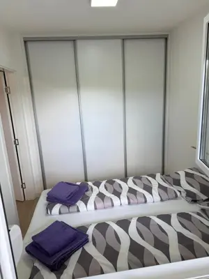 a bedroom with two beds with purple towels on them at Apartman Premium in Doboj