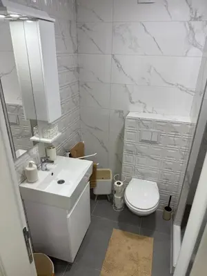 a white bathroom with a sink and a toilet at Apartman Premium in Doboj