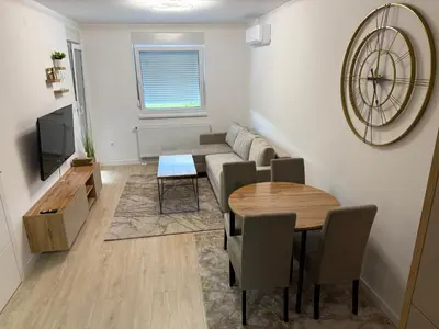 a living room with a couch and a table at Apartman Premium in Doboj