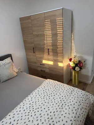 a bedroom with a bed and a dresser with flowers at Apartman Sofija in Doboj