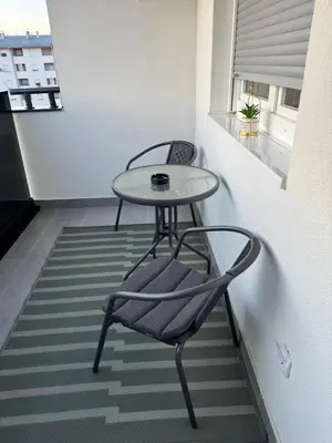 a small table and a chair in a small room at Apartman Sofija in Doboj