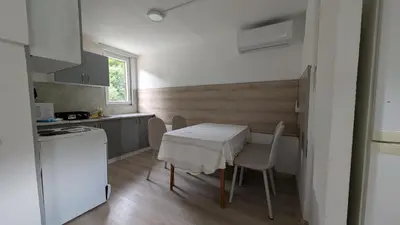 a small kitchen with a white table and chairs at River`s Song Cottage Jajce in Jajce