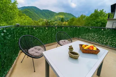 a table and chairs with a basket of fruit on a balcony at River`s Song Cottage Jajce in Jajce