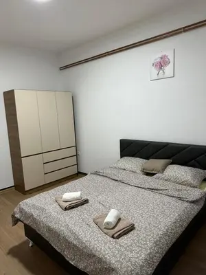a bedroom with two beds with towels and a cabinet at Apartmani Samardzic in Bosanska Gradiška
