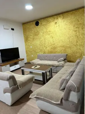 a living room with two couches and a tv at Apartmani Samardzic in Bosanska Gradiška