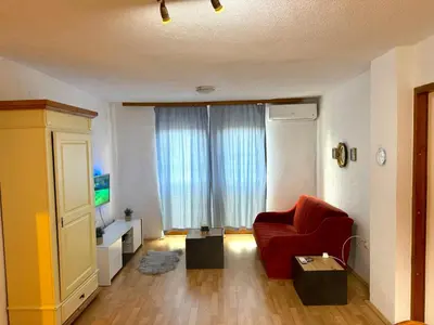 a living room with a red chair and a television at New Hill house in Visoko