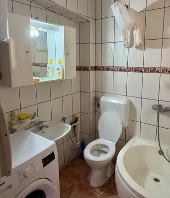 a bathroom with a toilet and a sink and a washing machine at New Hill house in Visoko