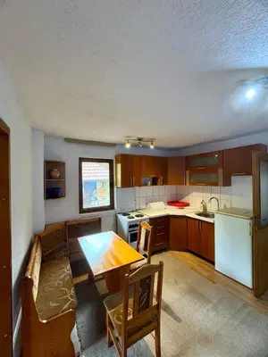 a small kitchen with a table and a table and chairs at New Hill house in Visoko