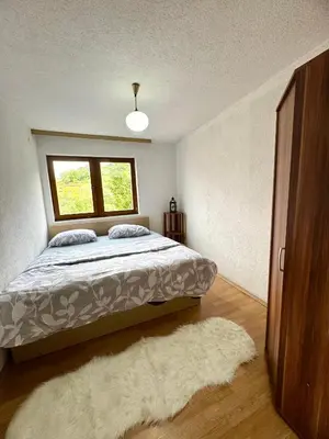 a bedroom with a bed and a window and a rug at New Hill house in Visoko