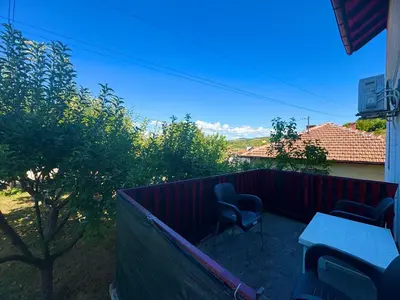 a patio with two chairs and a table and a fence at New Hill house in Visoko