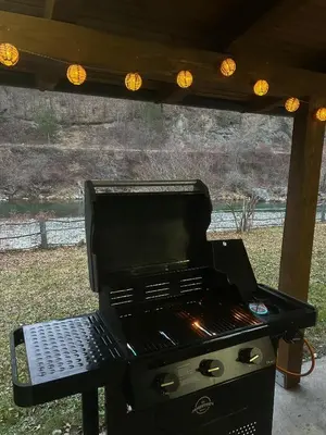 a grill under a porch with lights on it at Krivaja River Retreat - Jacuzzi, Pool and Basketball