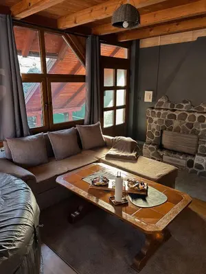 a living room with a couch and a coffee table at Krivaja River Retreat - Jacuzzi, Pool and Basketball
