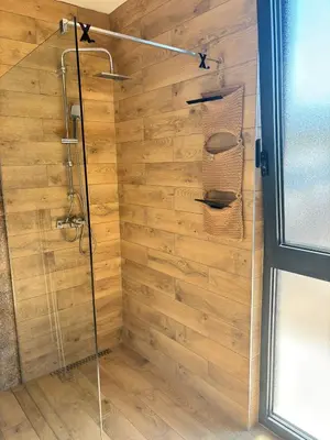 a shower with a wooden wall at Villa Stone House