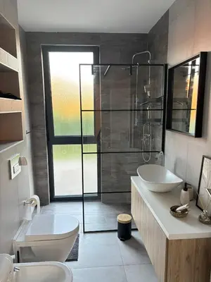 a bathroom with two sinks and a glass shower at Villa Stone House