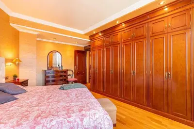 a bedroom with wooden cabinets and a large bed at Moderan smještaj s parkingom Nova Bila in Nova Bila