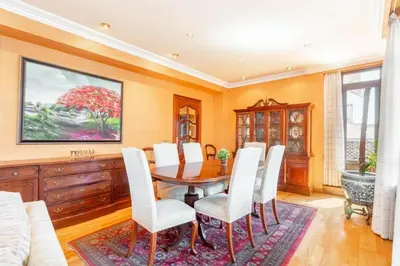 a dining room with a wooden table and white chairs at Moderan smještaj s parkingom Nova Bila in Nova Bila