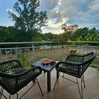 a patio with two chairs and a table with a pizza on it at Vikendica na Sani Datea in Sanski most